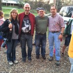 Four people standing outside, smiling for a photo.