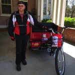 Man with red jacket and tricycle.