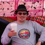 Man wearing a Nationals hat and holding a cup.