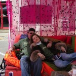 Man and woman relaxing on a couch under a canopy.