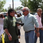 Two men talking at a crowded outdoor event.