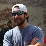 Man in a blue shirt wearing sunglasses and a hat.