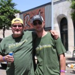 Two men smiling in front of a building.