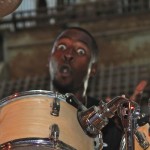 Man playing drums with surprised expression.