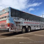 American Queen tour bus parked on street.