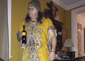 Man in a yellow robe holding wine.