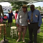 Two men standing together at a flea market.