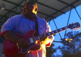 Man playing electric guitar on stage.