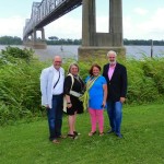 Four people stand by a bridge.