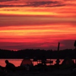 Silhouettes at sunset by a lake.