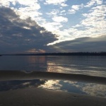 Cloudy sky reflected in calm water.