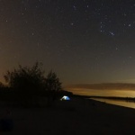 Night sky with stars and a tent.