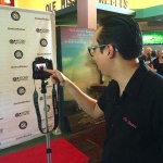 Man filming with camera at film festival.