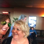 Two women smiling for a photo in a theater.