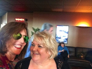 Two women smiling for a photo in a theater.