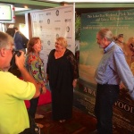 A man photographs a group of people at a film premiere.