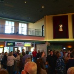 Crowded lobby with people waiting for a movie.