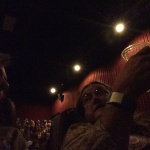 Two people in a dark movie theater.