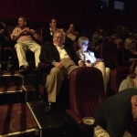 Group of people watching a movie in a theater.