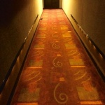 Carpeted hallway with patterned floor.