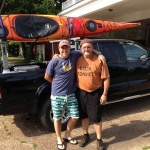 Two men with a kayak on a truck.