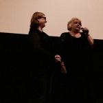 Two women speaking at a microphone.