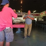 Two men standing in a restaurant.