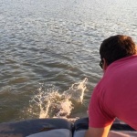 Man in pink shirt watching water splash