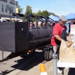 Black smoker trailer at a food festival.