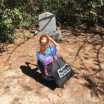 Woman taking photo of a grave.