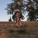 Woman taking a photo on a hill.