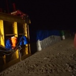 A man looks up at night near a truck.