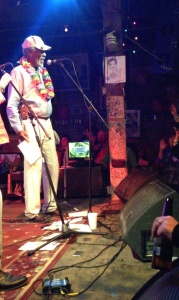 Man with white hat singing on stage.