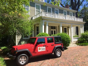 Red Jeep parked in front of a house.