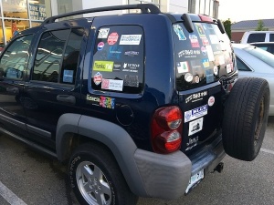 Blue Jeep with many stickers on the back.