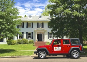 Red Jeep parked in front of a house.