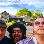 Three men smiling in front of Dockery Farms.