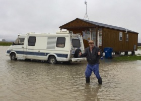 Man in flooded area giving thumbs up.