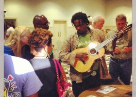 Man plays guitar for group of people.