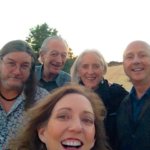 Group portrait of five smiling people outdoors.