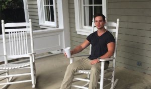 Man sitting on a porch rocking chair.