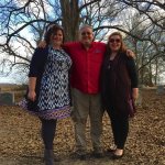 Three friends posing in a cemetery.