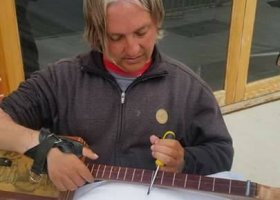 Man working on a cigar box guitar.