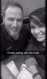 Couple smiling, eating at a restaurant.