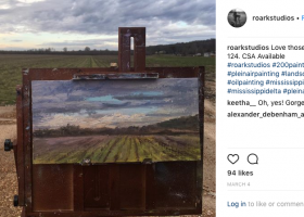 Landscape painting on an easel outdoors.