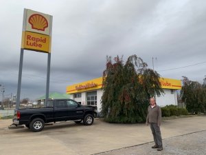 Man standing near a Rapid Lube.