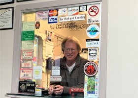 Man at a counter with a sign saying "We Care"