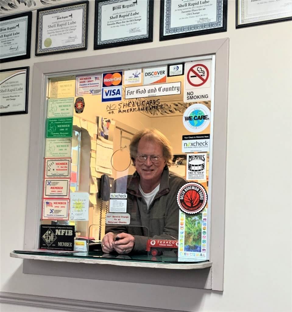 Man at a counter with a sign saying "We Care"