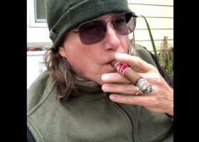 Man in sunglasses smoking a cigar.