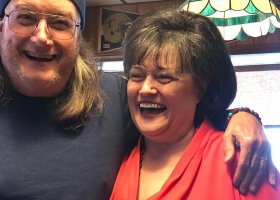 Two people smiling and laughing together.